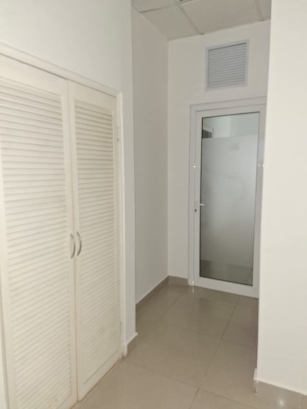 Interior corridor with frosted glass door louvered storage closet in Plaza Korintho Panama