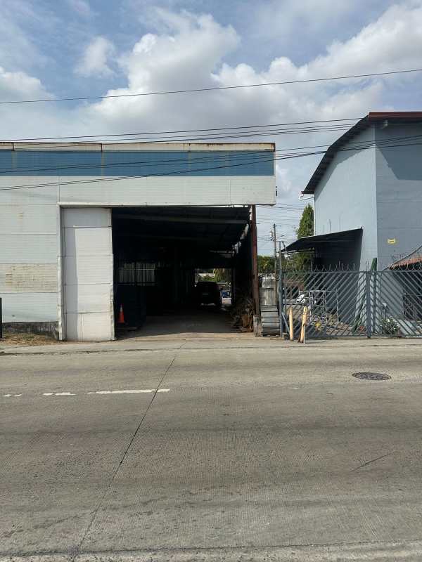 Industrial warehouse exterior with wide opening and fenced lot on Vía Tocumen Panama City