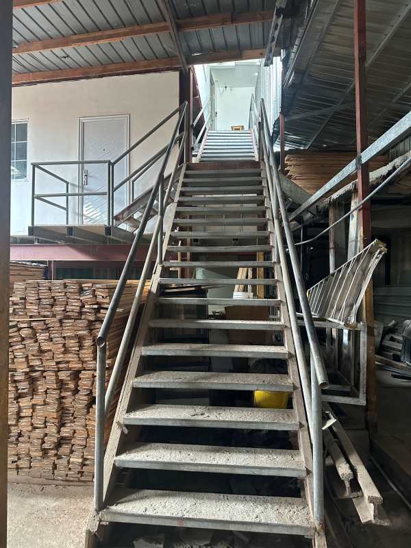 Warehouse interior featuring stairs to mezzanine with wood storage Llano Bonito Panama
