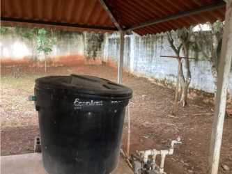 Covered exterior utility space with water tank in backyard Chitré Panama house