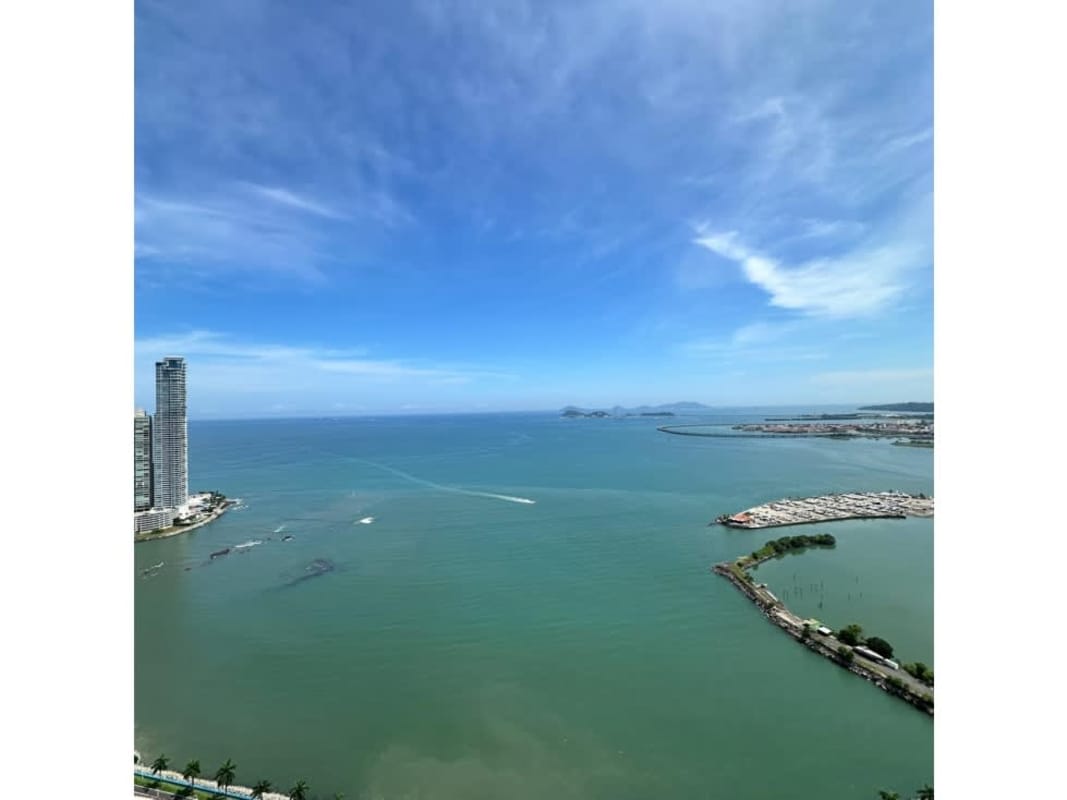 Contemporary living room with balcony access overlooking bay in luxury Panama condo