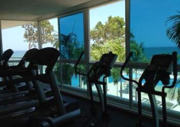 Glass-walled fitness center with ocean views at Santa Clara Residences Panama