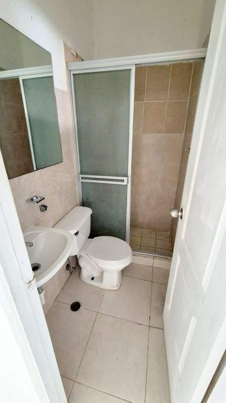 Half bathroom with porcelain sink, mirror, and silver accents in duplex Pedregal Panama