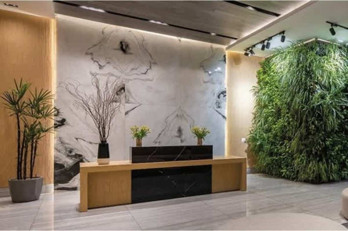 Contemporary lobby with marble accent wall, indoor garden, and modern reception in PH Velure Panama City