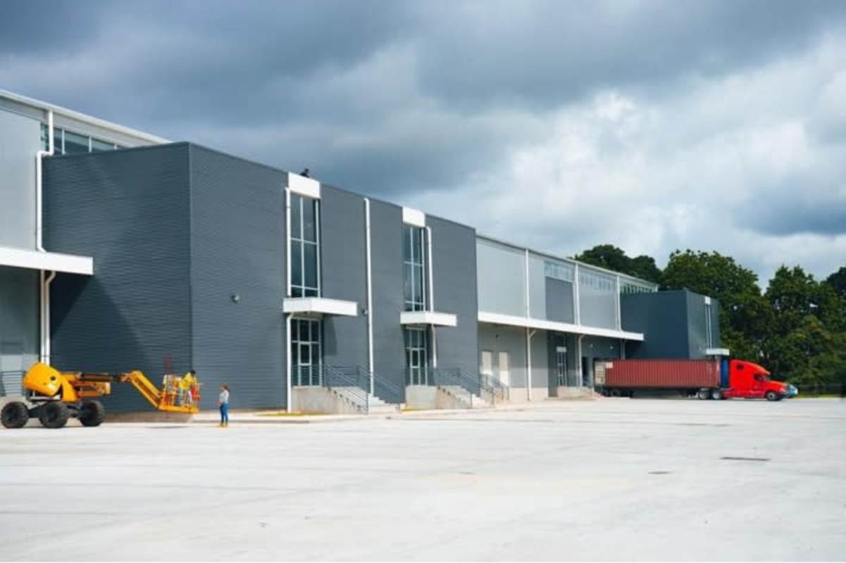 Wide view of modern warehouse with loading docks and trucks at Panama Logistics Park