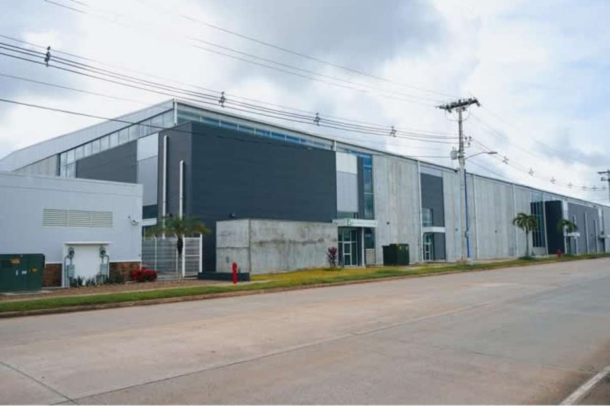 Facade with concrete, glass, and metal panels in Panama Logistics Park with palm landscaping