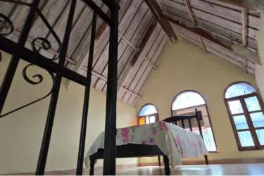 Rustic bedroom with vaulted ceiling and large arched windows in Coronado Panama