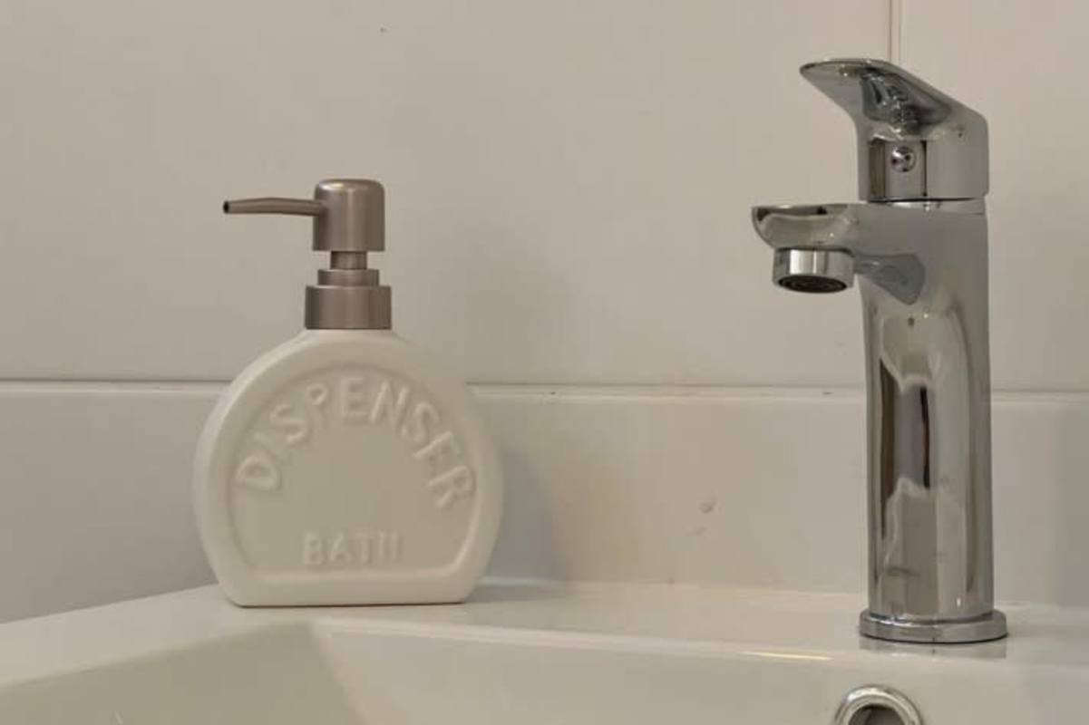 Minimalist modern bathroom with chrome faucet, porcelain sink at PH Park View San Francisco