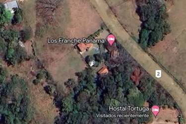 Aerial coastal Panama land with multiple small buildings, open fields near Guanico Beach