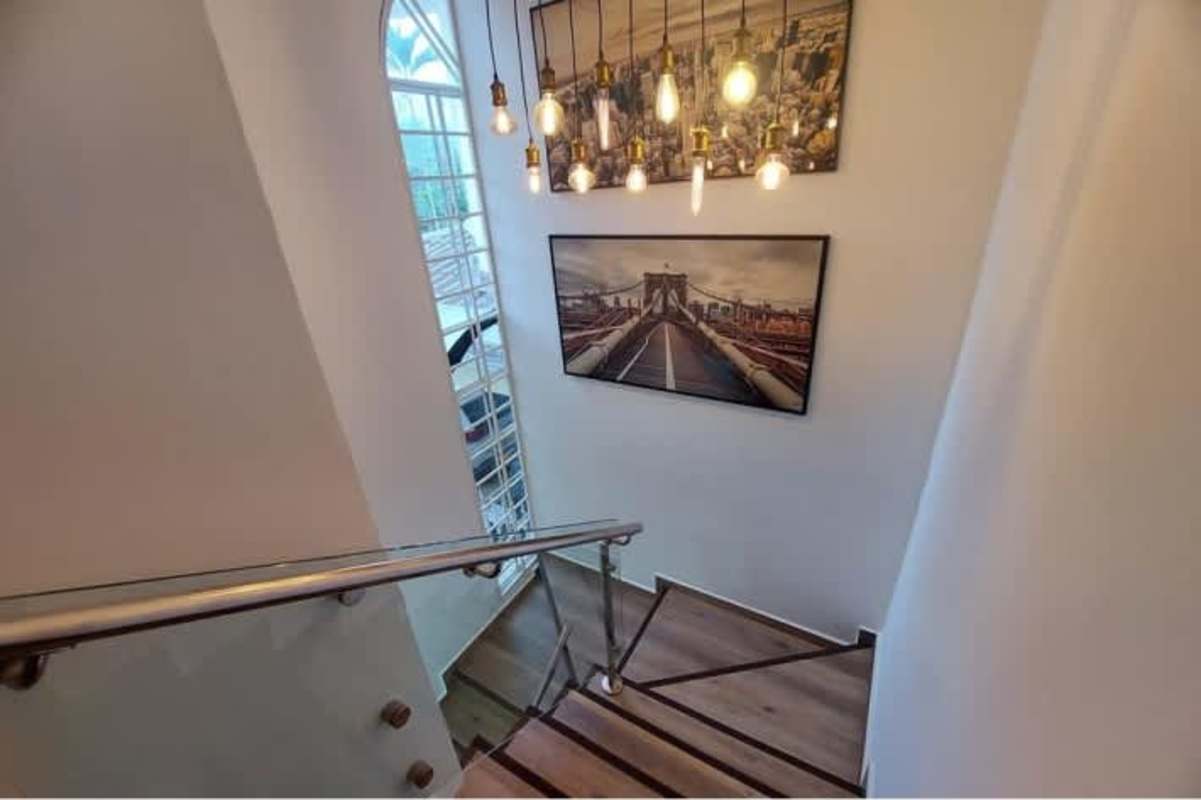 Stairwell large window pendant light wood steps Green Valley Albrook Panama