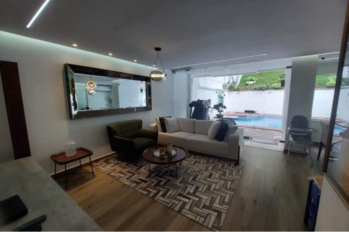 Living room with wood accent wall, sectional sofa, mirror Green Valley Albrook Panama