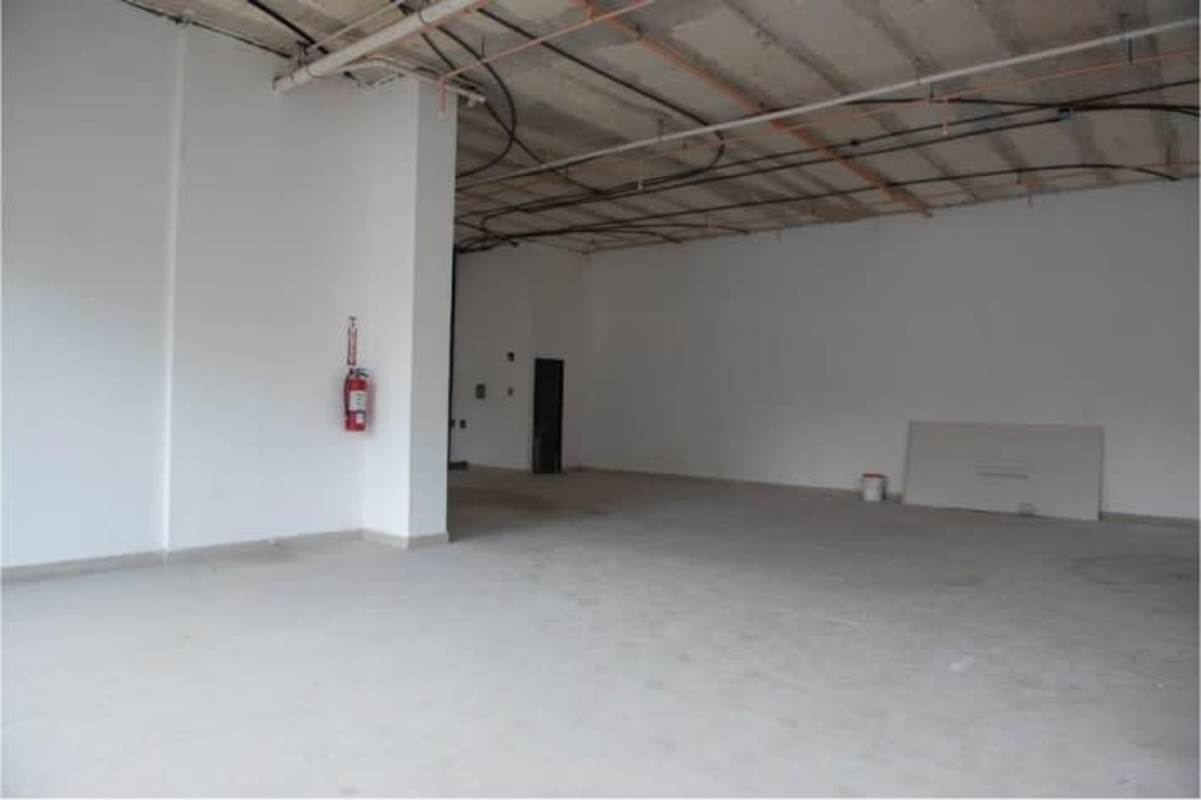 Unfinished commercial interior ready for leasing with white walls and exposed wiring at Bella Vista Global Plaza