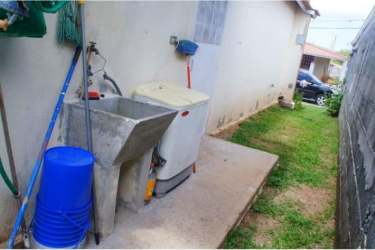Laundry point with utility sink and washing machine area behind family house in La Chorrera Panama