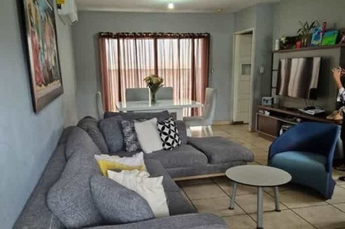 Dining area with white table, upholstered chairs and flower centerpiece in Brisas del Golf house Panama City