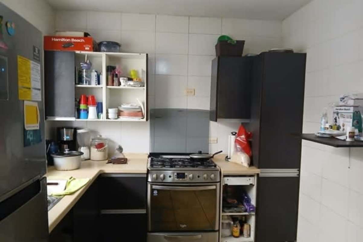 Modern bathroom with glass shower, vanity sink and tiled walls at Brisas del Golf house for sale