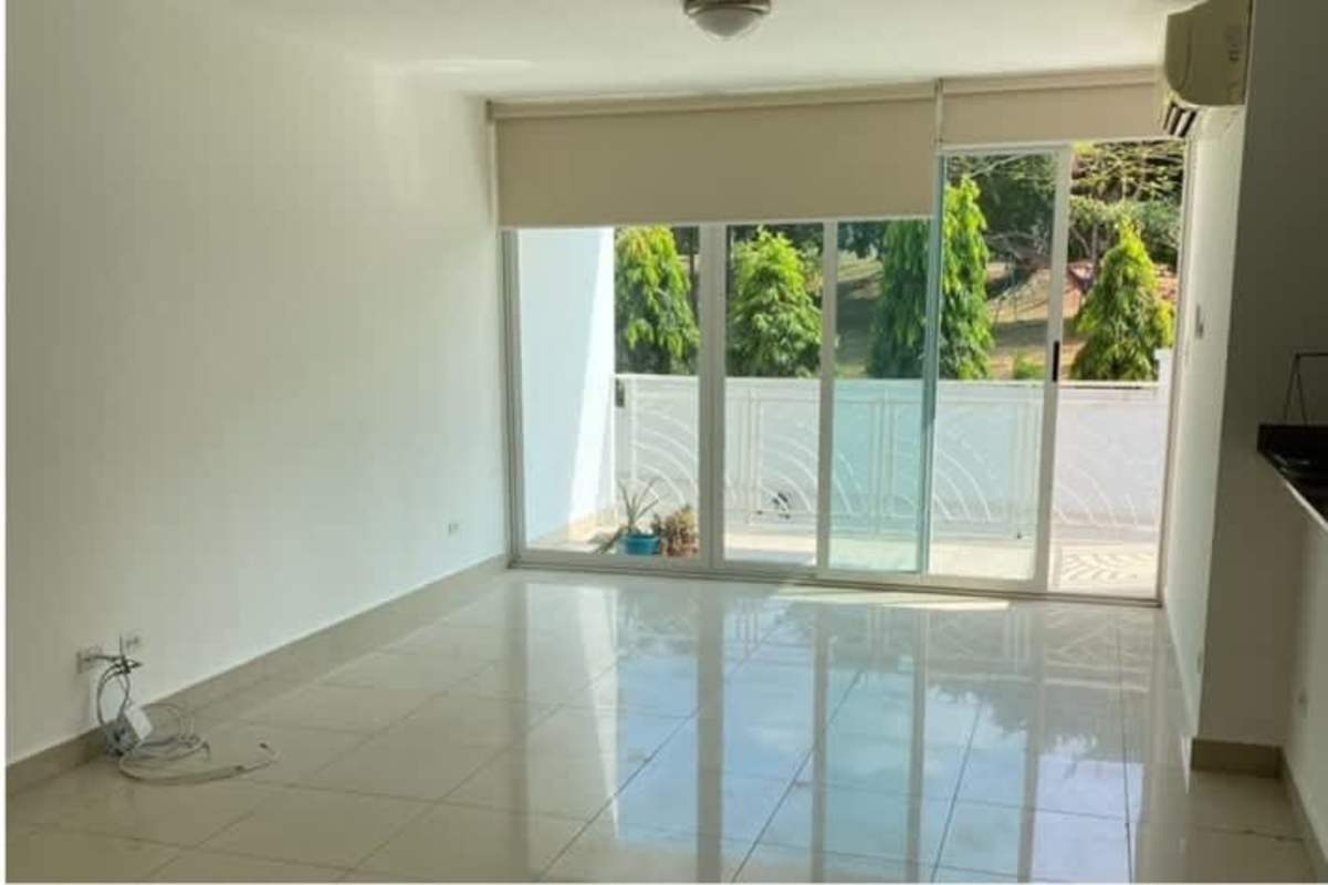 Living room with large sliding doors opening to balcony garden view PH Sun City Panama