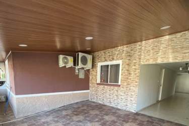 Entrance gate of Residencial La Arboleda Los Avellanos with landscaping and security booth