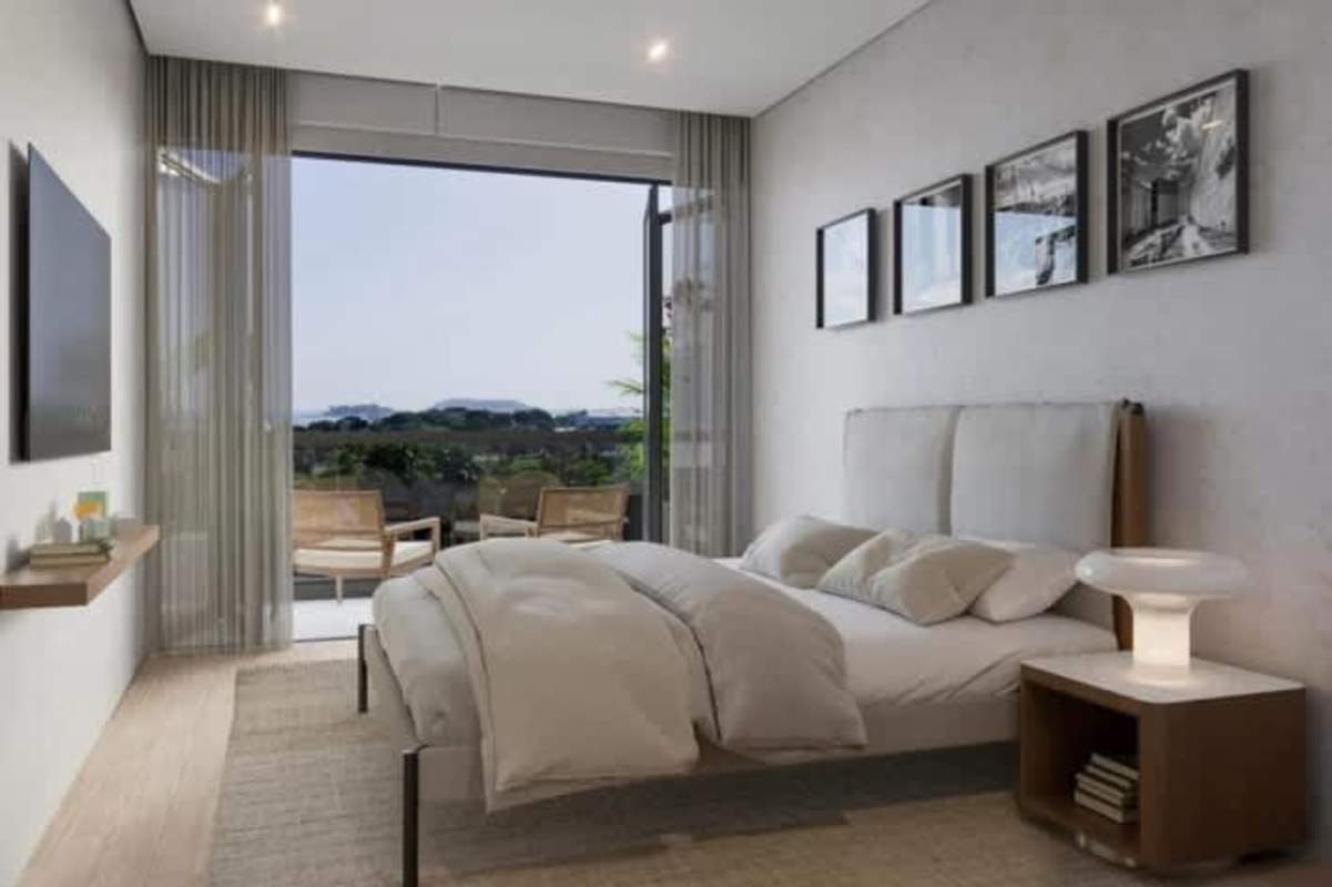 Bedroom with large glass door opening to balcony facing water Passage Amador Panama
