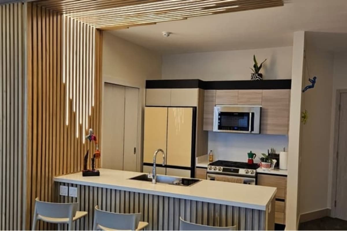 Contemporary living room with marble accent wall and flat-screen TV in Santa Maria Panama apartment