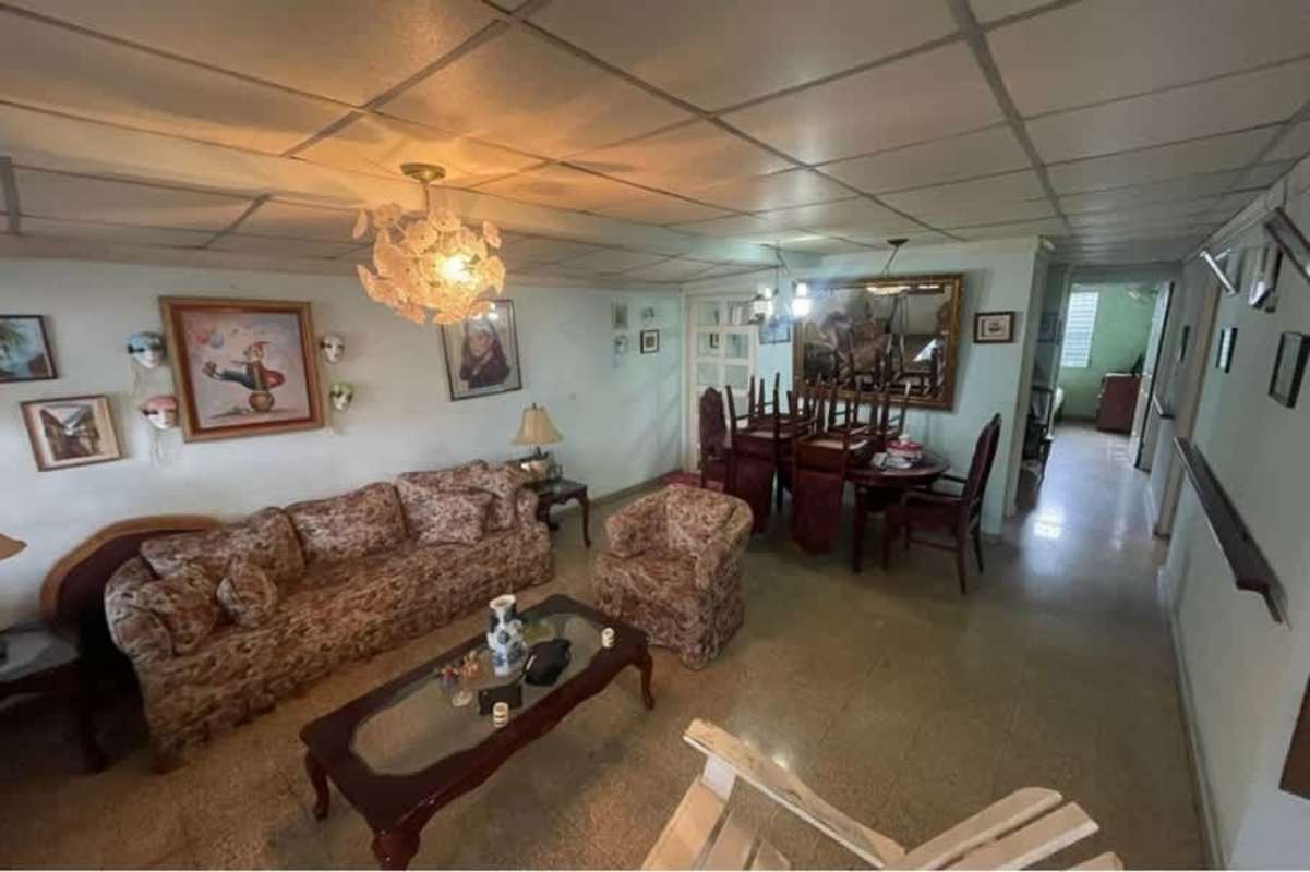 Bedroom with wood closet, AC, fan, and barred window in Villa Lucre Panama