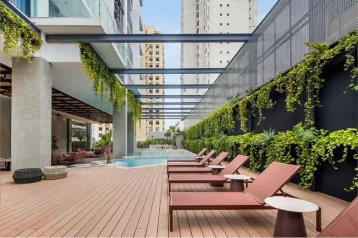 Modern infinity swimming pool area with loungers, vertical garden, and pergola PH Velure Panama City