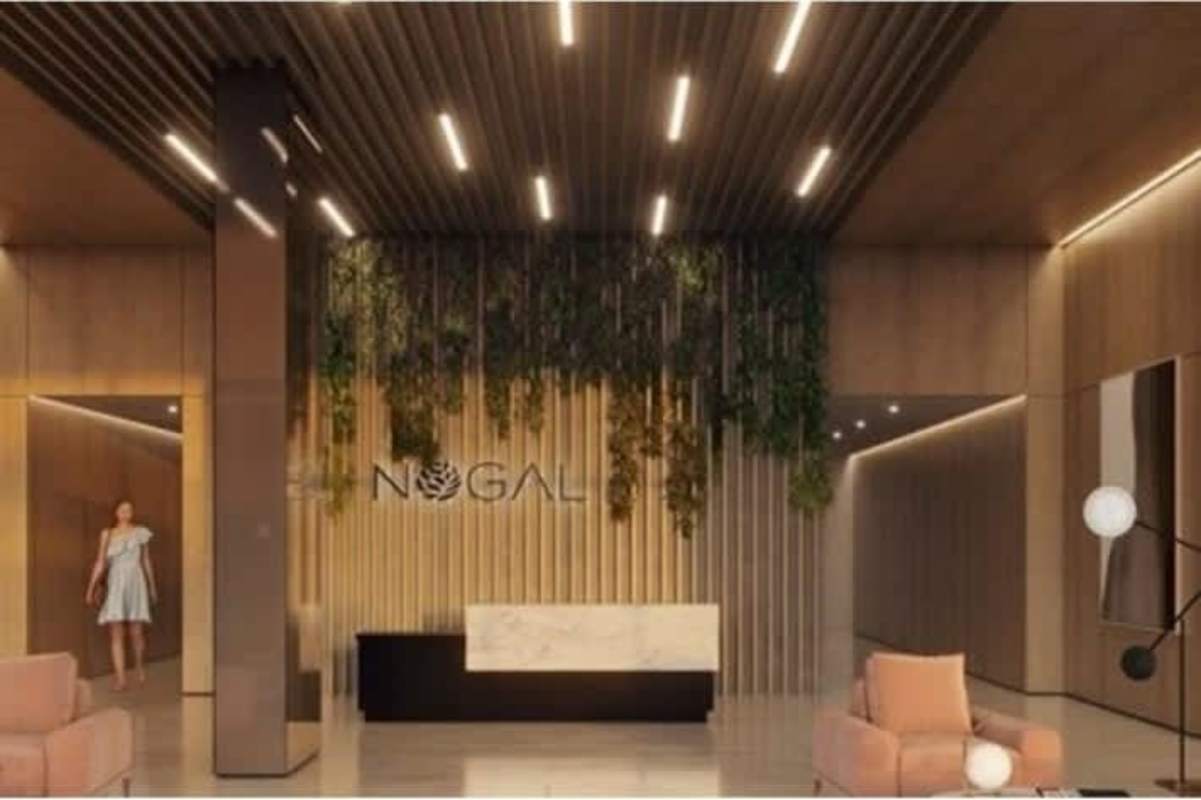 Modern building lobby with wood paneling, plants, and reception desk at PH Nogal in Costa del Este Panama