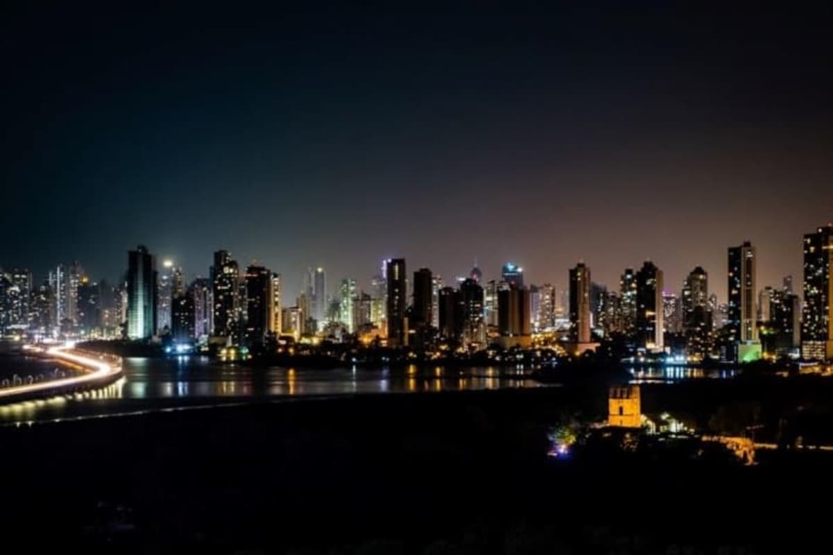 Night skyline of Panama City with illuminated towers and riverfront seen from Costa del Este