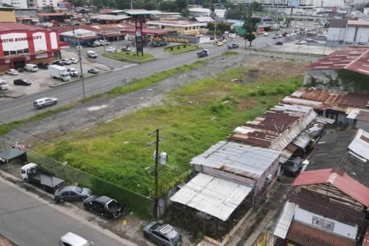 Drone view corner lot facing McDonald's on major Panama City road surrounded by shops and buildings