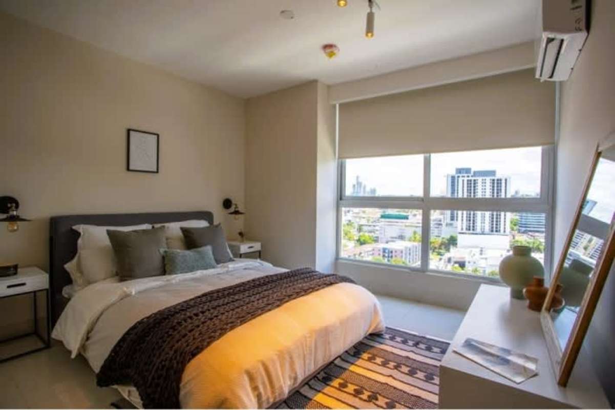 Modern bedroom with large window, closet and city skyline view in PH Isabella Towers Carrasquilla