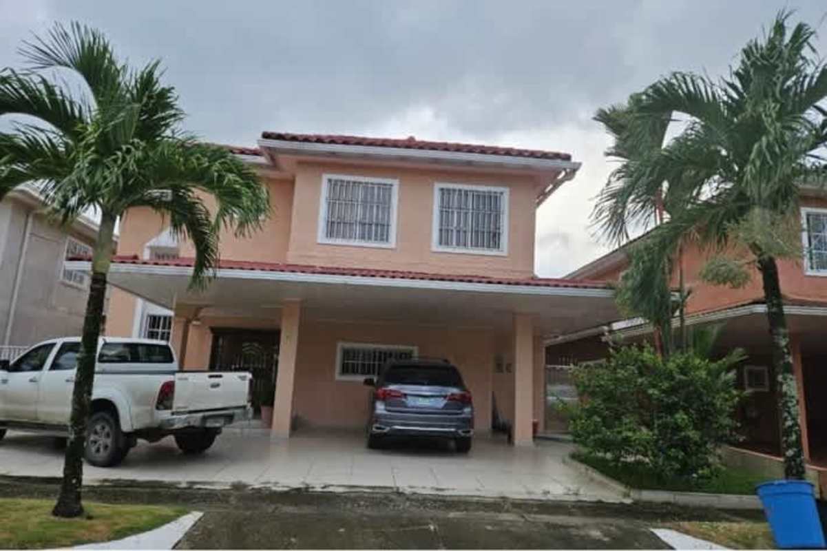 Covered carport with tiled driveway and palm landscaping at duplex house in Ciudad del Sol Colón Panama