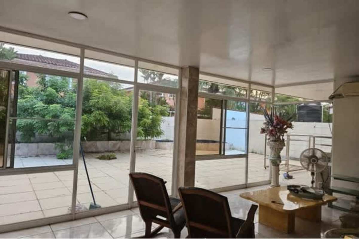 Modern living room with large windows connecting to patio garden in duplex house Ciudad del Sol Colón Panama