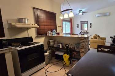 Open kitchen and living room with breakfast bar and stone accents in Las Lajas Panama