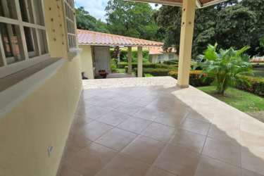 Covered outdoor patio with tiled floor and landscaped garden in Chame, Panama