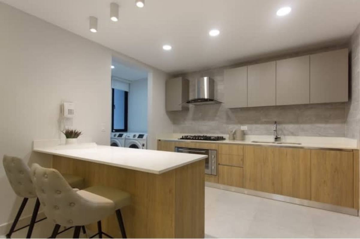 Kitchen with island, wood cabinets, washer dryer space at Condado Country Club Condado del Rey Panama