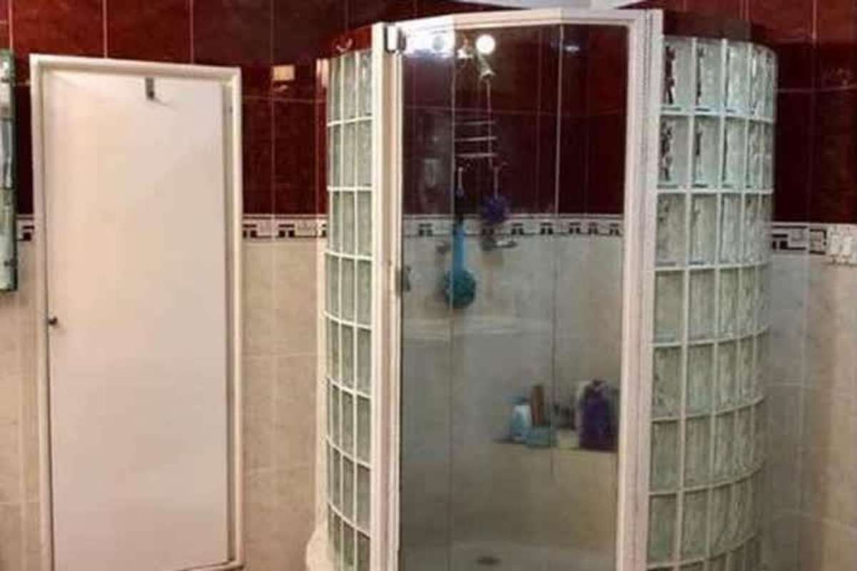 Bathroom with curved glass block walk-in shower enclosure in Betania duplex