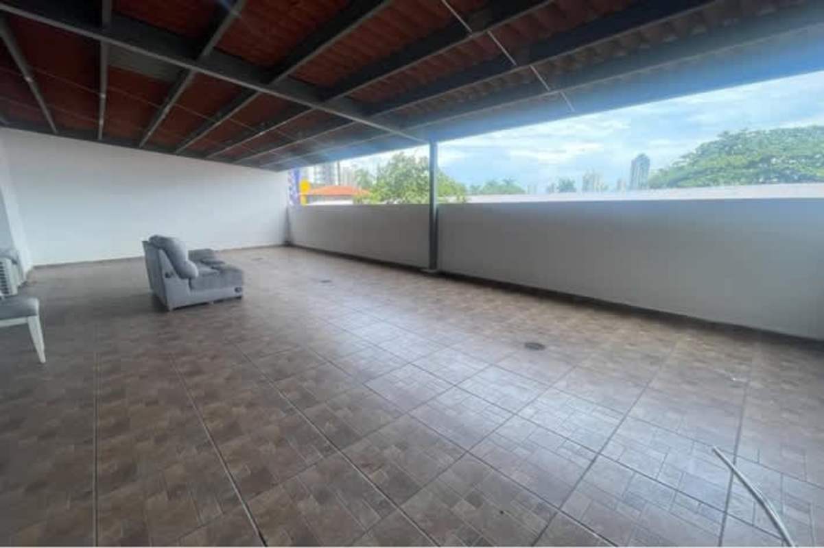 Covered outdoor lounge area with black furniture city skyline view PH Vía España Panama City