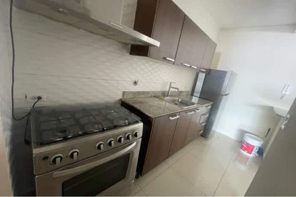 Kitchen with granite countertops, brown cabinets, stove, refrigerator in PH Vía España Río Abajo Panama for rent