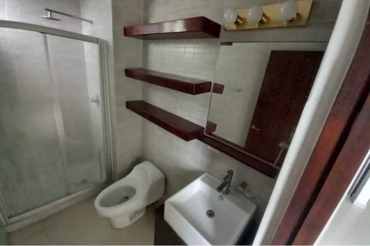 Minimalist bathroom with glass shower, wall-mounted shelves PH Altamira Gardens Panama