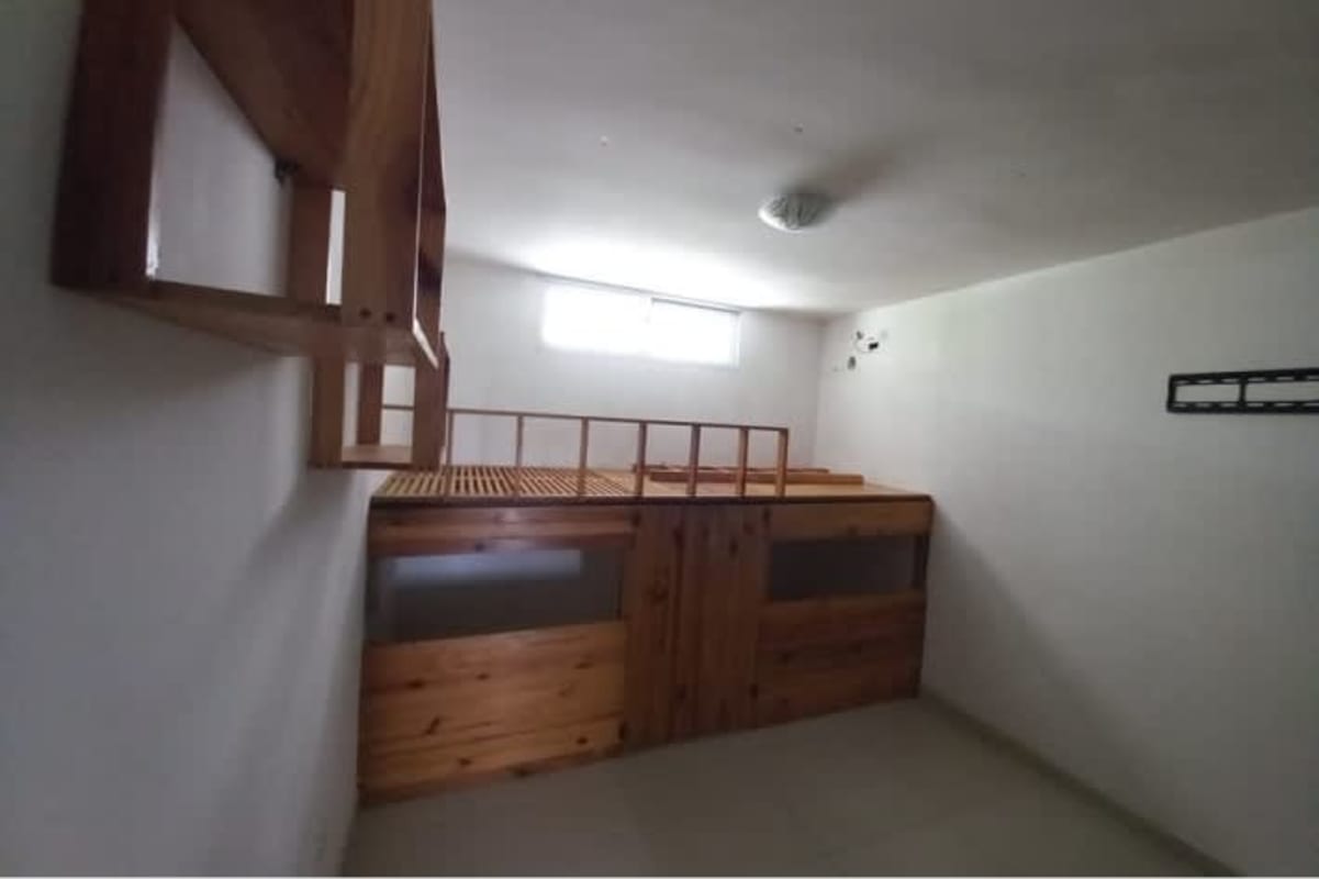 Minimalist bedroom with lofted platform, shelves and tiled floor in PH Altamira Gardens Panama