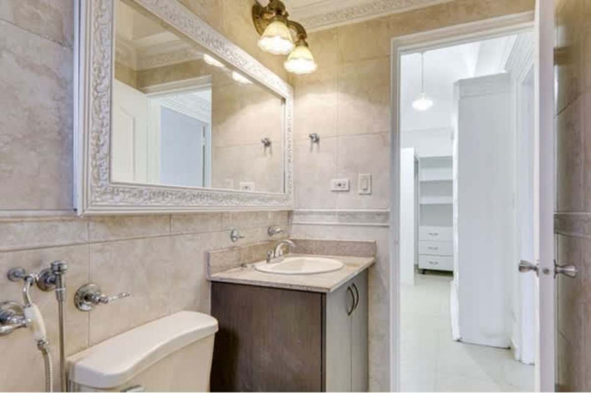Elegant bathroom with framed mirror, vanity and beige tiles in Versalles 1 Costa Sur