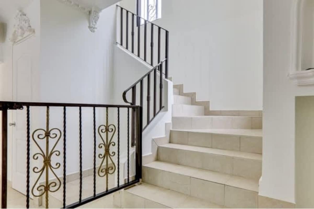 Interior staircase with iron railings, tiles and window grill in duplex Costa Sur Panama
