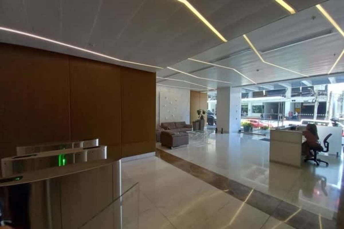 Modern lobby with marble floors, reception, seating and accent wall inside PH Atrium Tower Obarrio Panama