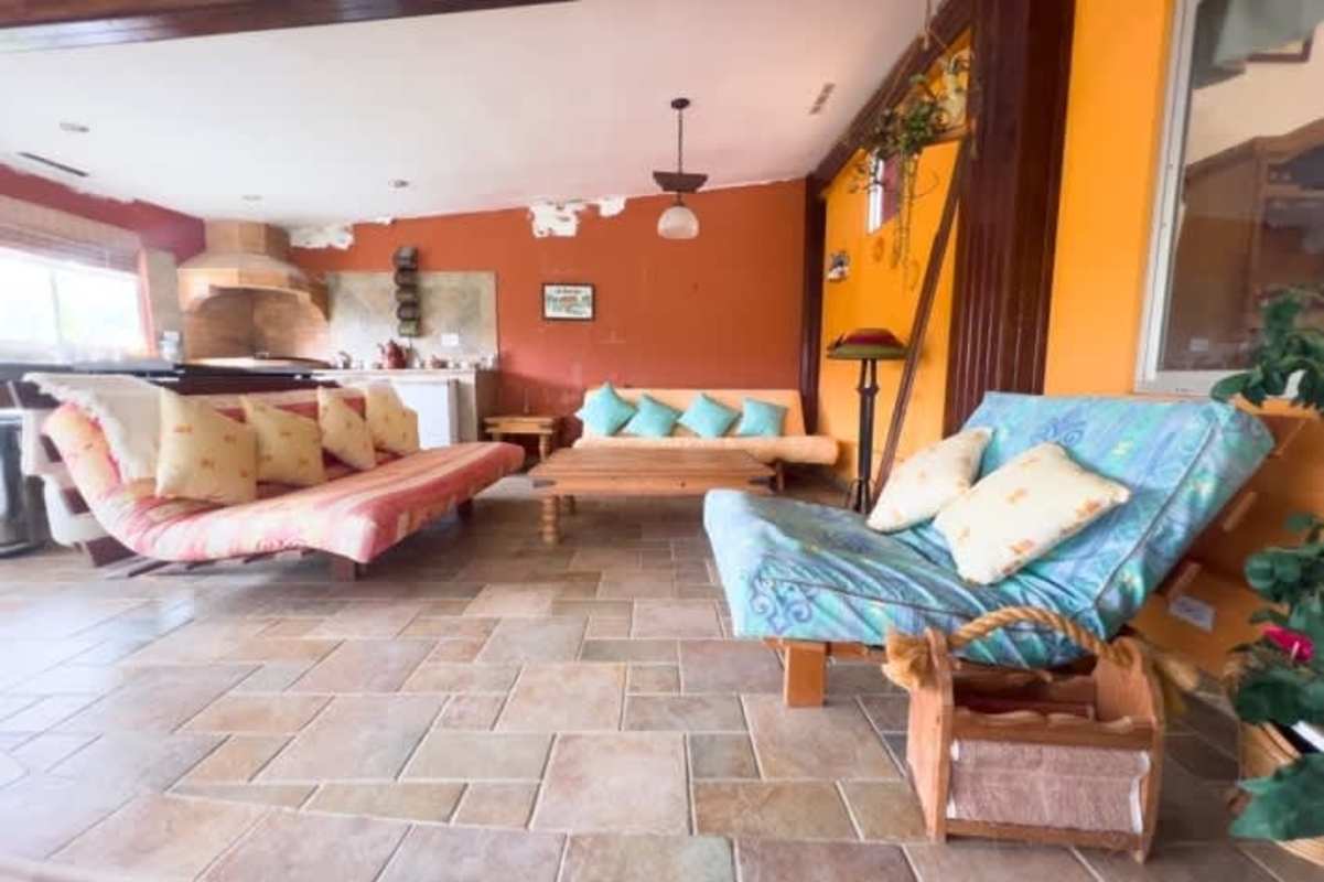 Bright enclosed sunroom patio with screen windows, hot tub and rustic details in mountain home Cerro Azul Panama