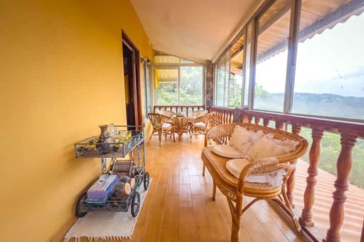 A-frame loft bedroom with hardwood floors and panoramic windows in mountain cabin Cerro Azul Panama