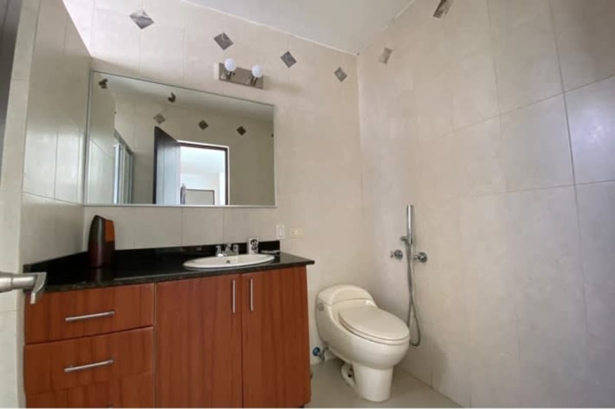Bathroom with mirror, wood vanity, black countertop PH San Francisco Bay Panama