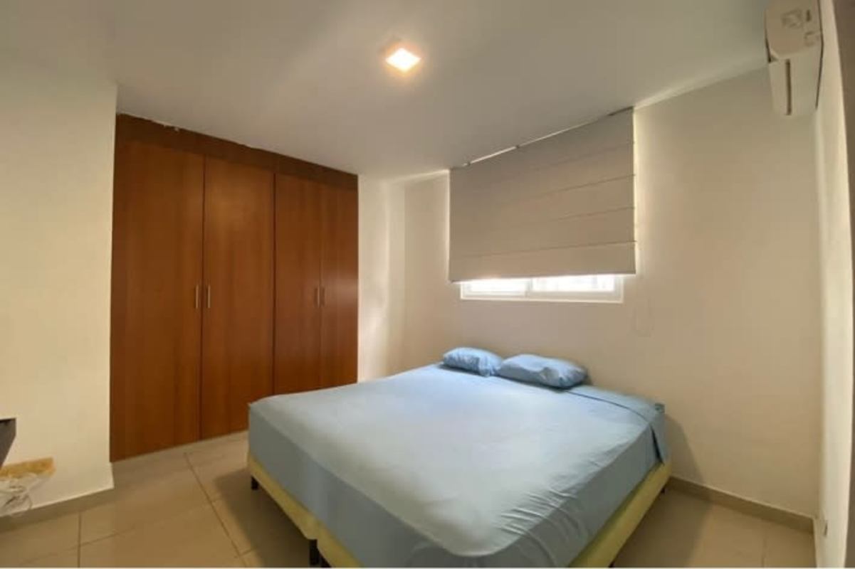 Bedroom with blue linens, built-in wood closet, window PH San Francisco Bay Panama