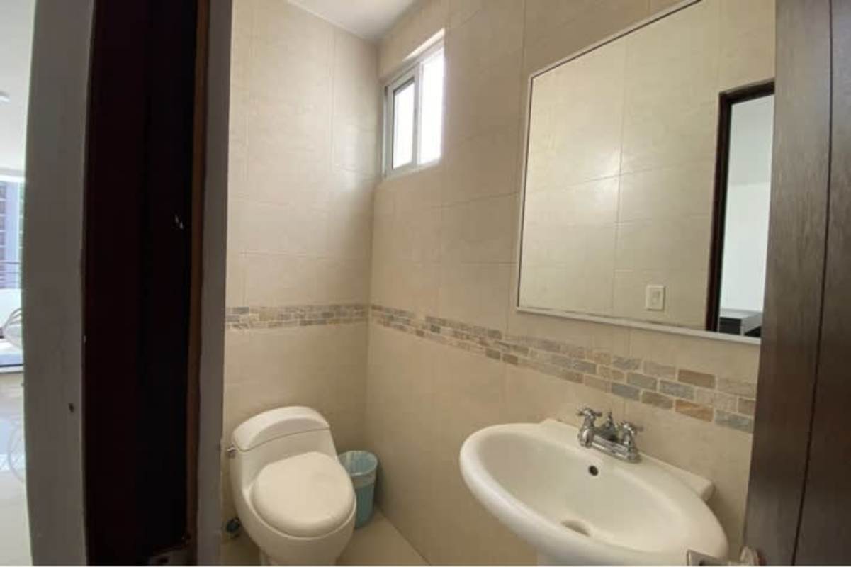 Minimalist bathroom with beige tiles, toilet, vanity, mirror PH San Francisco Bay Panama