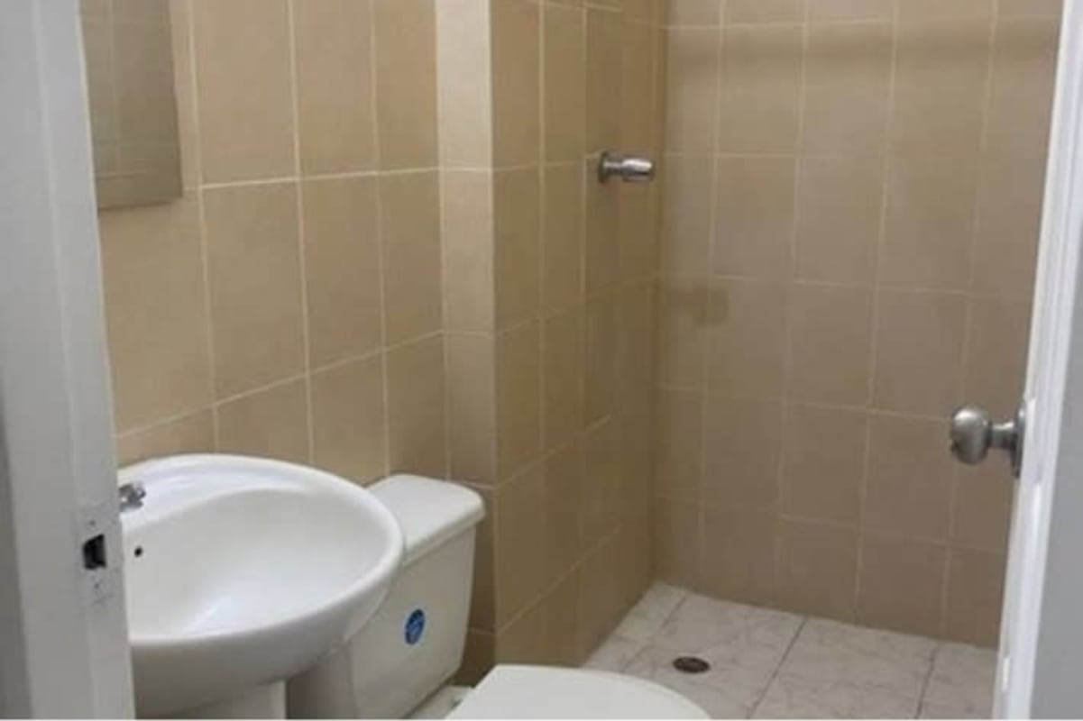 Minimalist bathroom with beige tile pedestal sink and toilet PH Mystic Blue Juan Díaz Panama