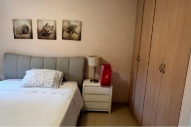 Bright minimal bedroom with light tile floors and built-in wooden closet in Coronado