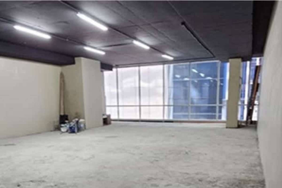 Elegant modern lobby entrance with glass security turnstiles, green wall, and elevators in Panama City office building